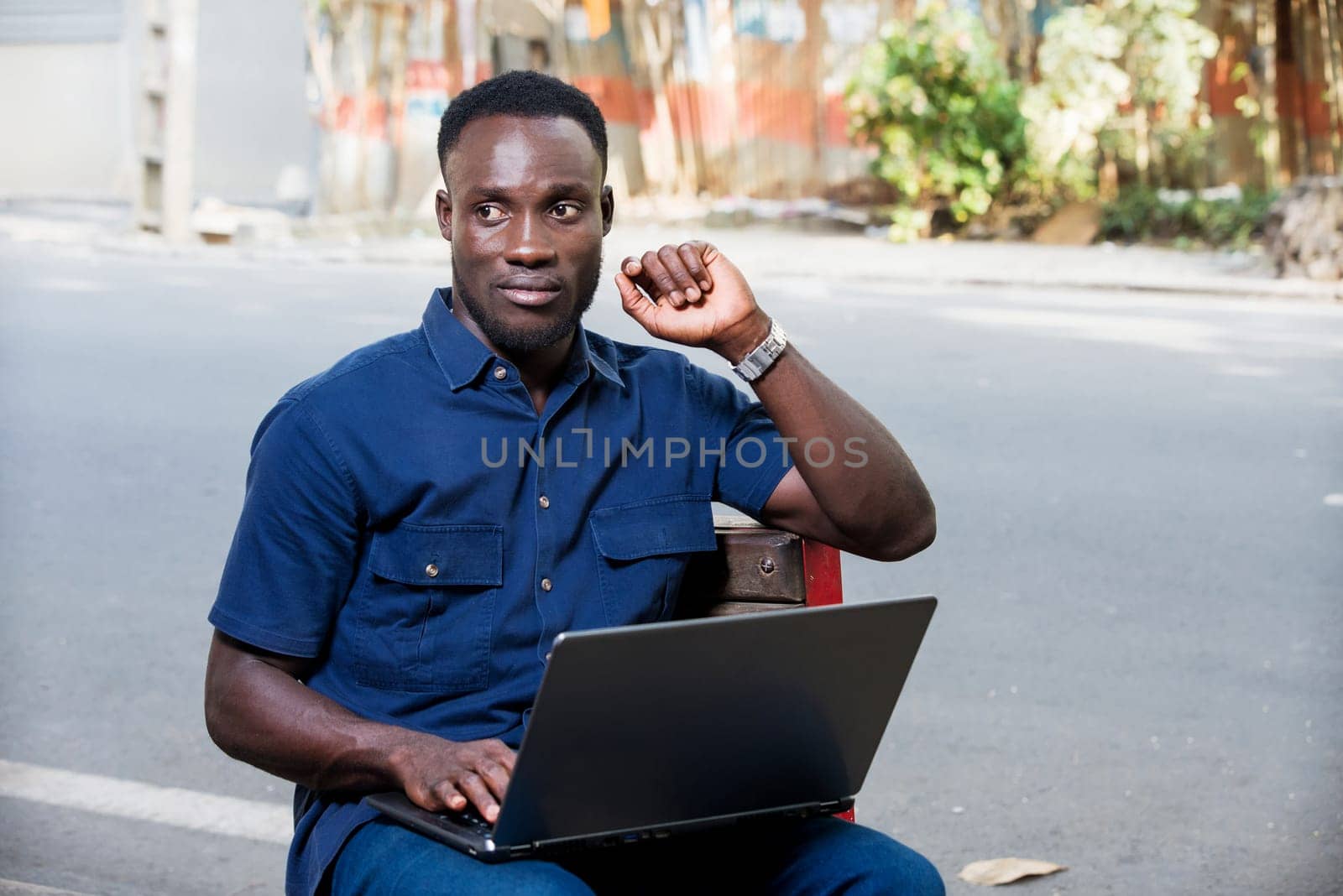 young man sitting outdoors thinking.