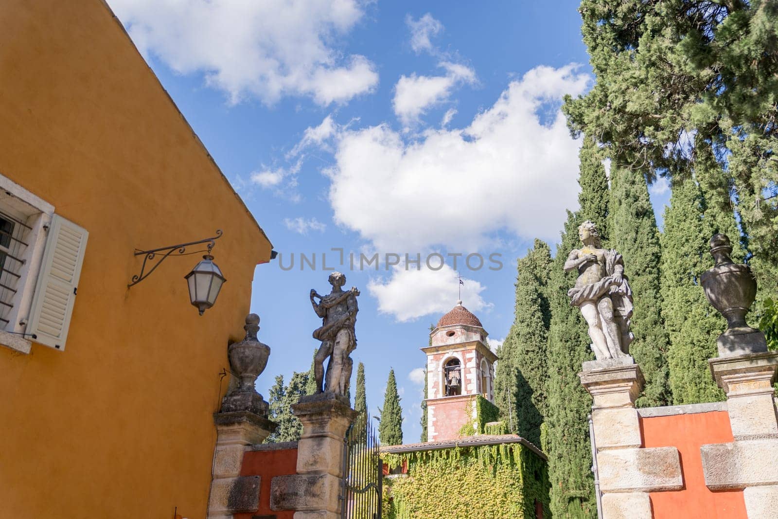 Antique sculptures stand on the gates of the ancient Villa Cordevigo. Italy by Nadtochiy