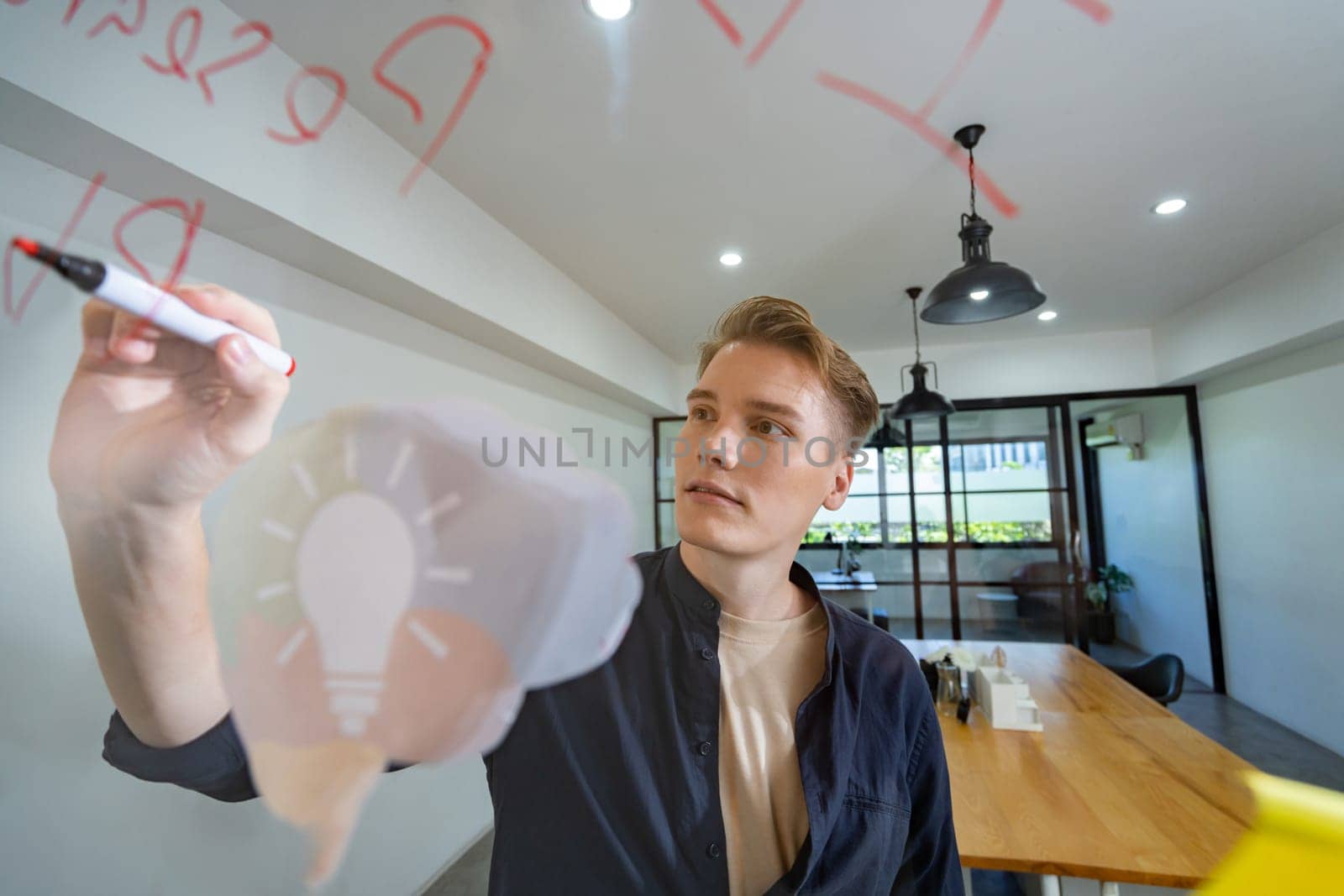 Professional caucasian businessman writing marketing idea by using mind map and sticky notes on glass board at modern meeting room. Creative business and planing concept. Closeup. Immaculate.