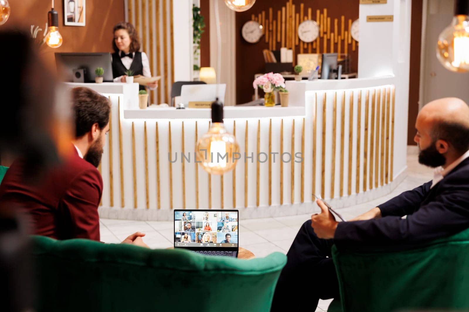 Businessman on videocall in hotel lobby by DCStudio