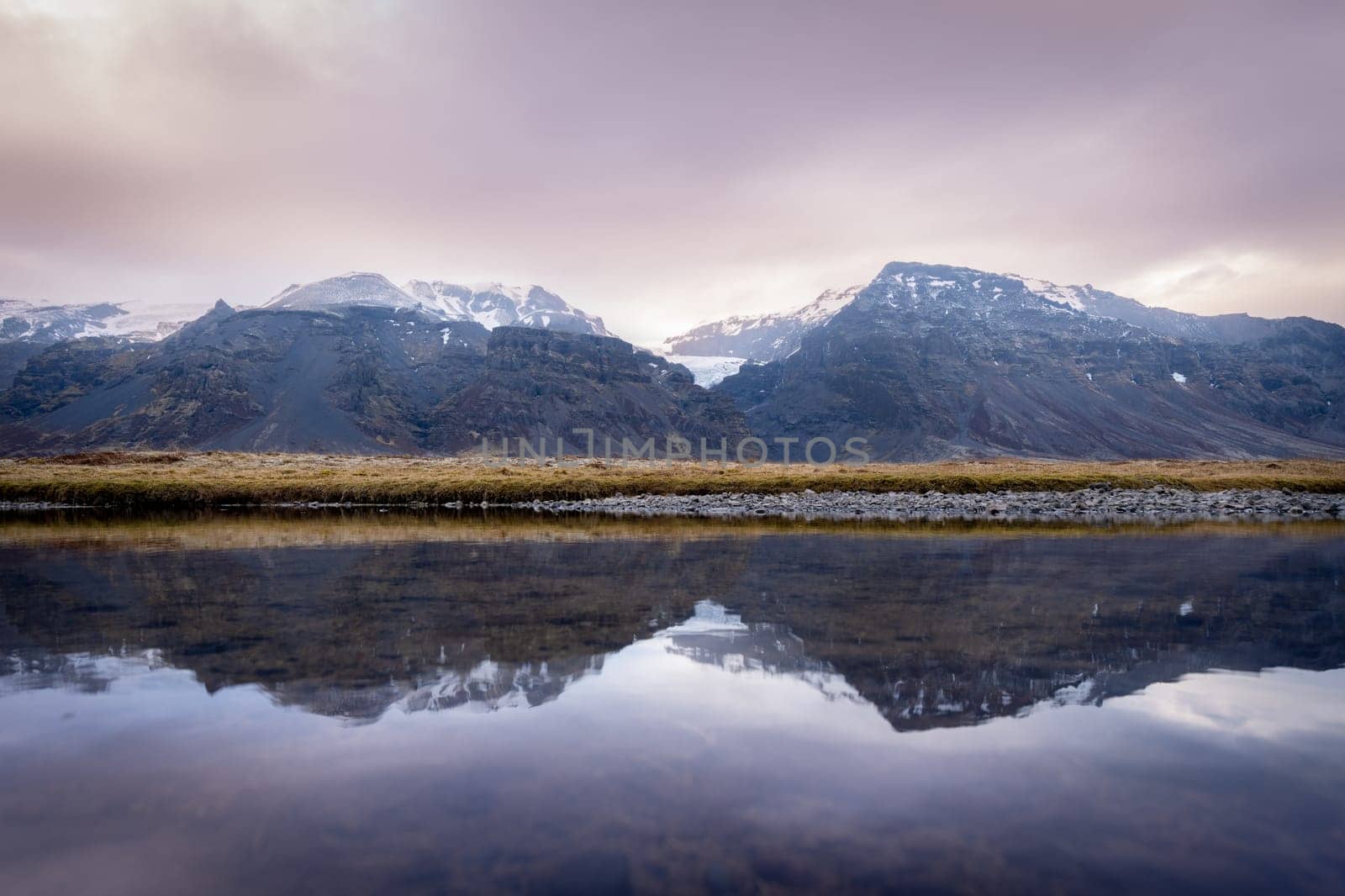 Mountaings and lake with her reflection in Iceland at sunset