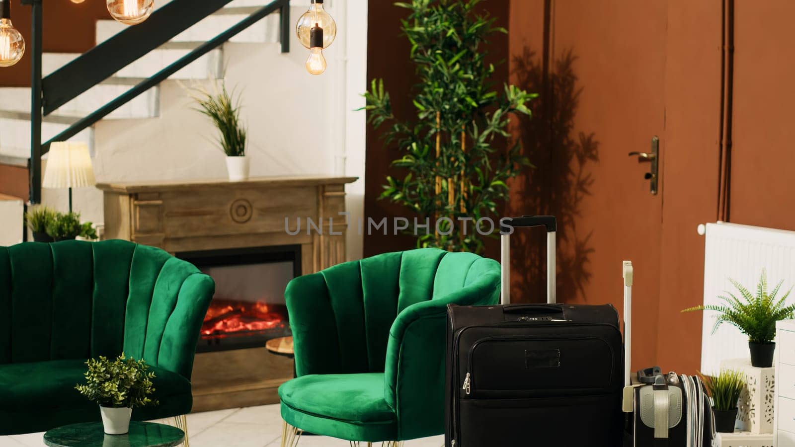 Modern empty lounge area with luggage and classy furniture, luxurious interior design in hotel lobby. Expensive rooms resort decorated with elegant lights and plants, trolley bags.
