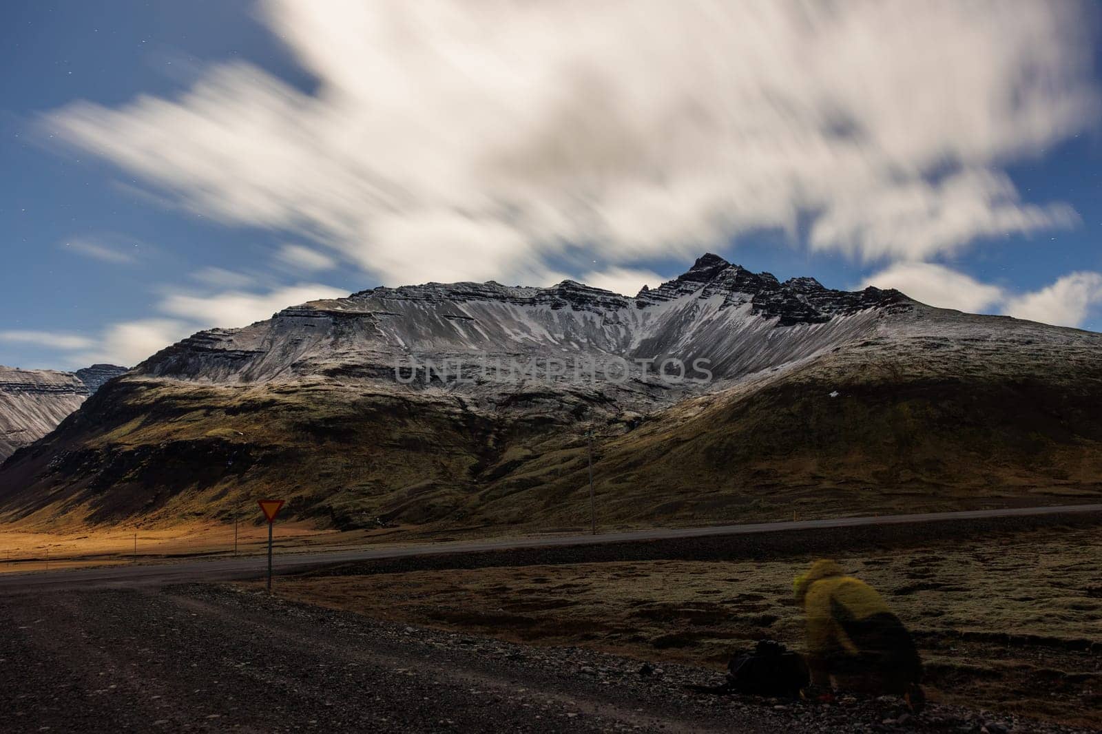 Dramatic snowy mountains along valley, night photography concept. Beautiful breathtaking view of snow covered peaks and frozen highlands within icelandic countryside, roadside scenery.