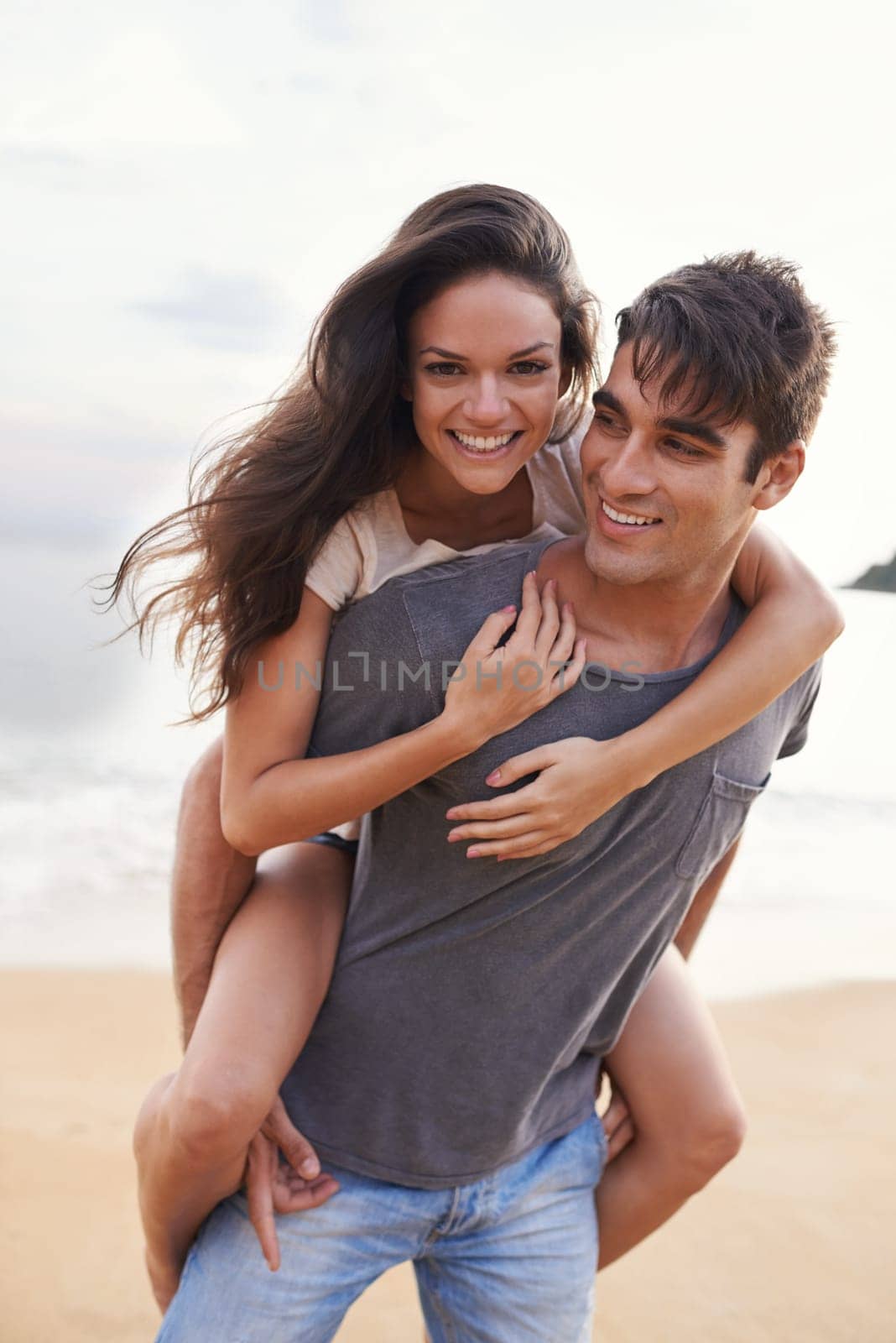 Couple, sea and piggyback with fun, smile and nature with travel and date for relationship. Man, woman and indonesia beach for adventure, vacation and tropical holiday with sunshine and portrait by YuriArcurs