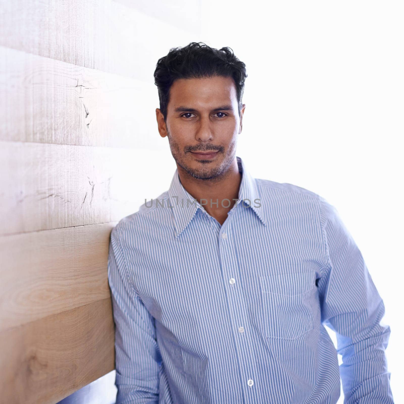 Businessman, portrait and confident professional by wood background and confidence in career in workplace. Designer, indian and face with pride in creative job, ambition and fashion shirt in office.