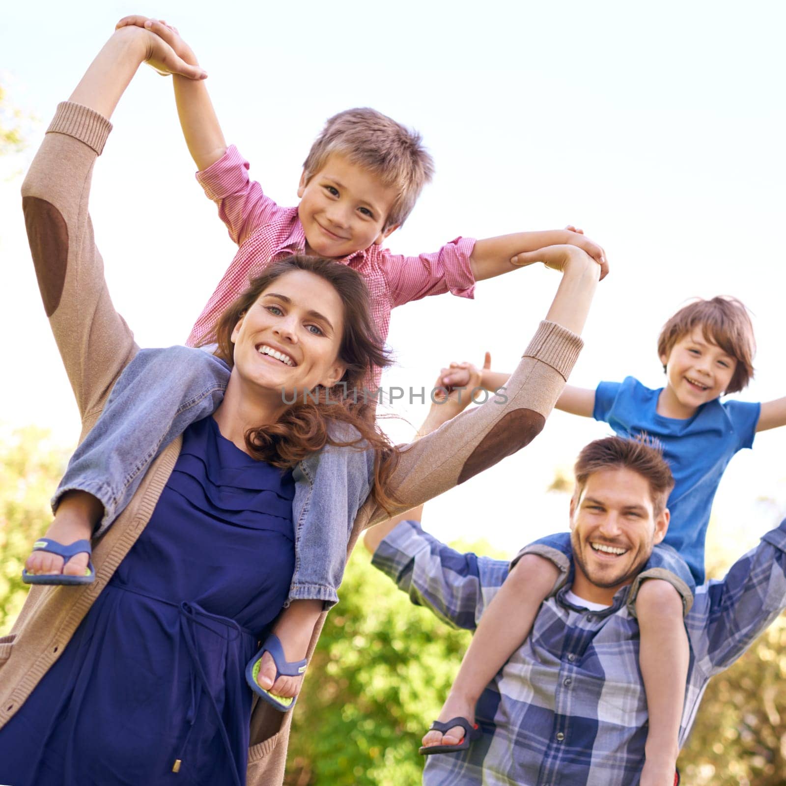 Smile, nature and children on parents shoulders in outdoor park or field for playing together. Happy, bonding and low angle portrait of mother and father carrying boy kids for fun in garden in Canada.