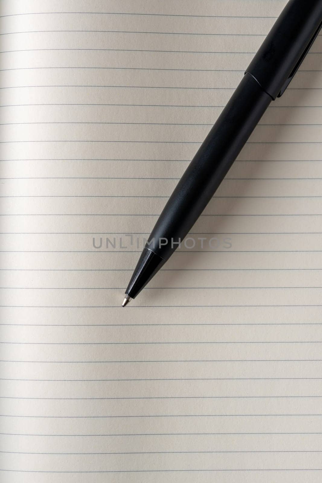 Top view of black ballpoint pen on lined note paper