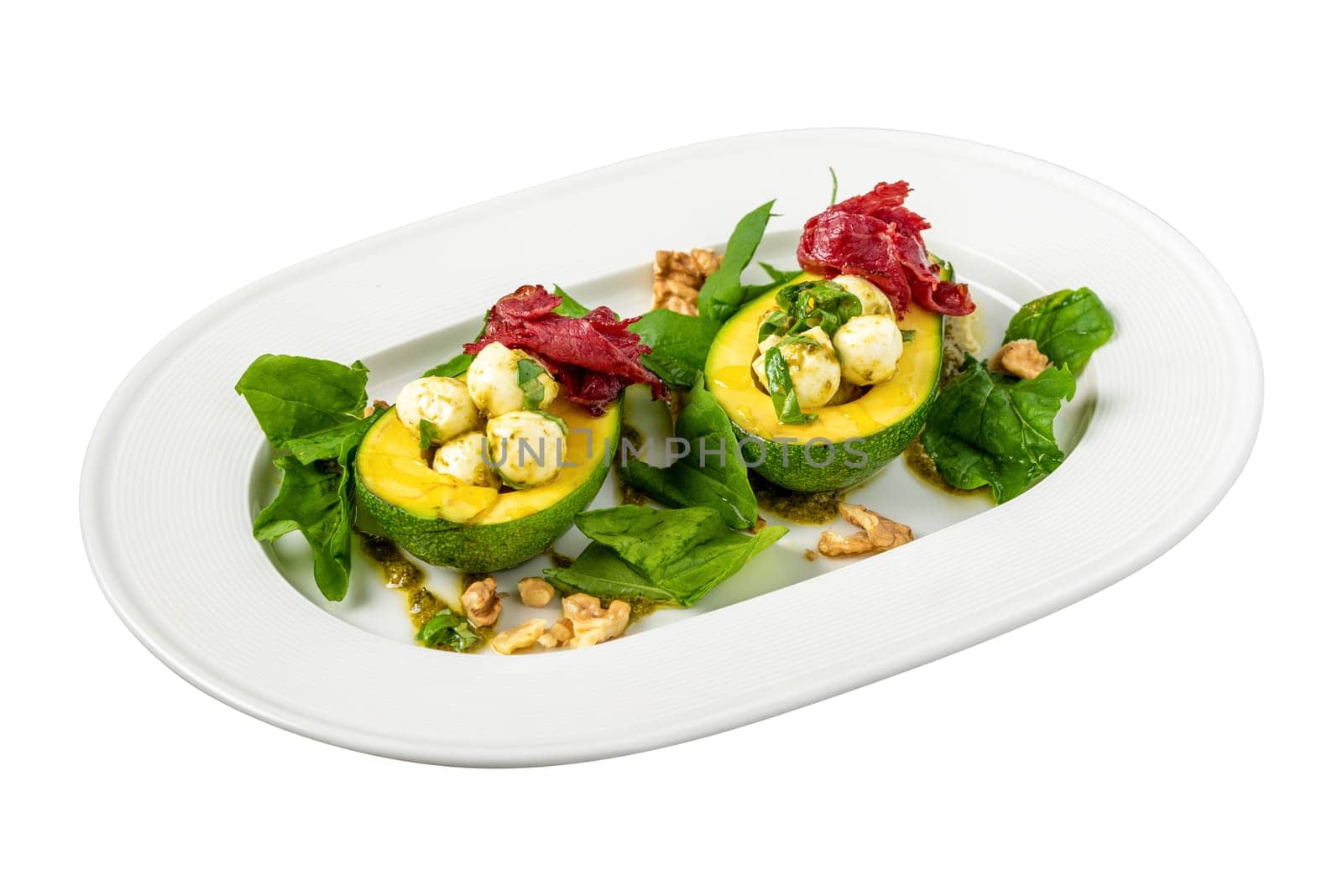Bocconcini cheese balls in halves of avocado served with salad on white background by Sonat