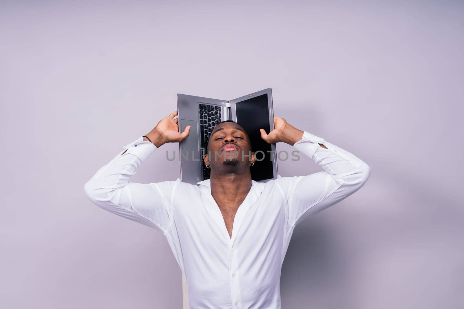 Young cheerful happy man of an African American ethnicity laptop pc computer studio portrait.