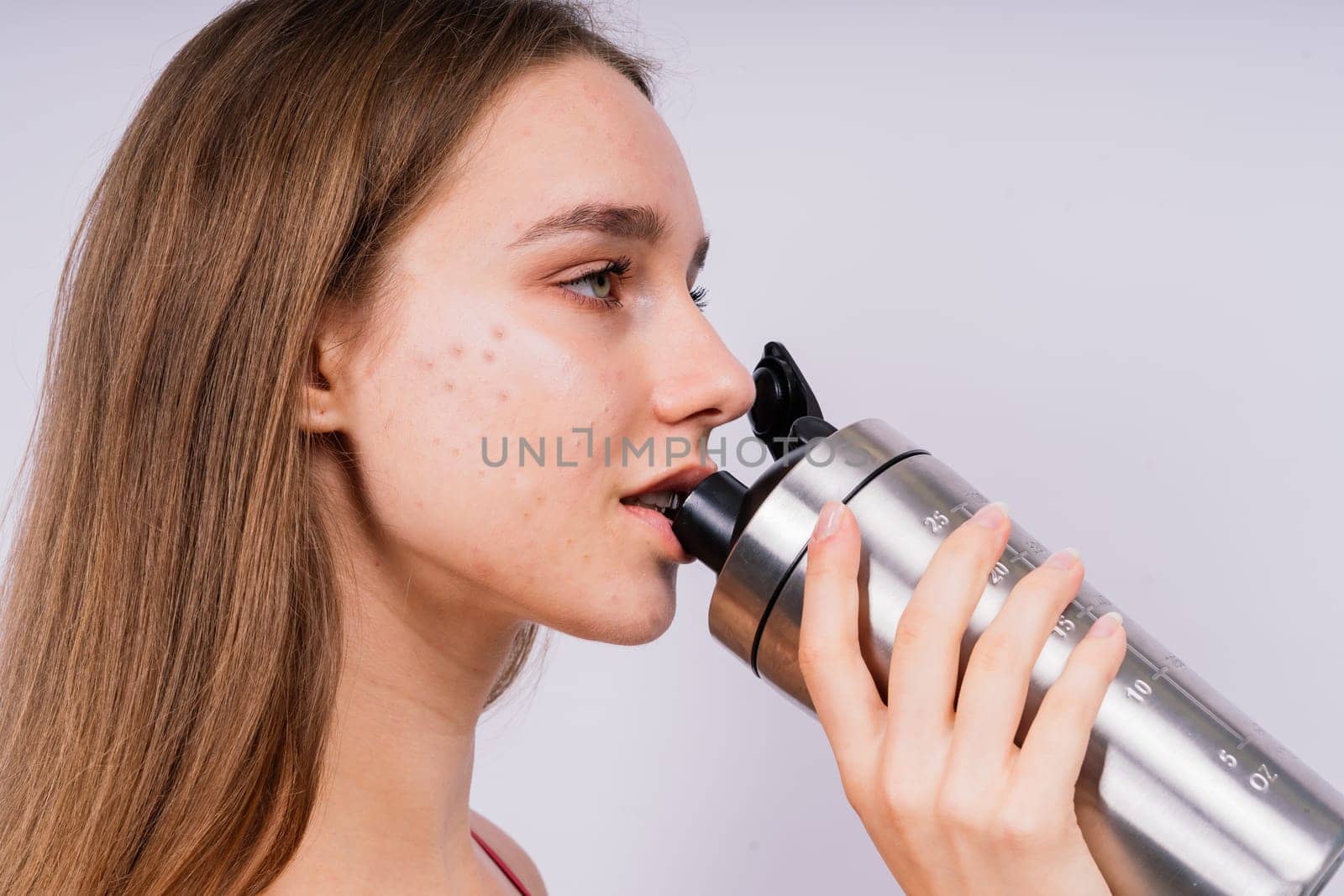 Image of beautiful strong happy cheerful young sport woman posing isolated indoors drinking water.