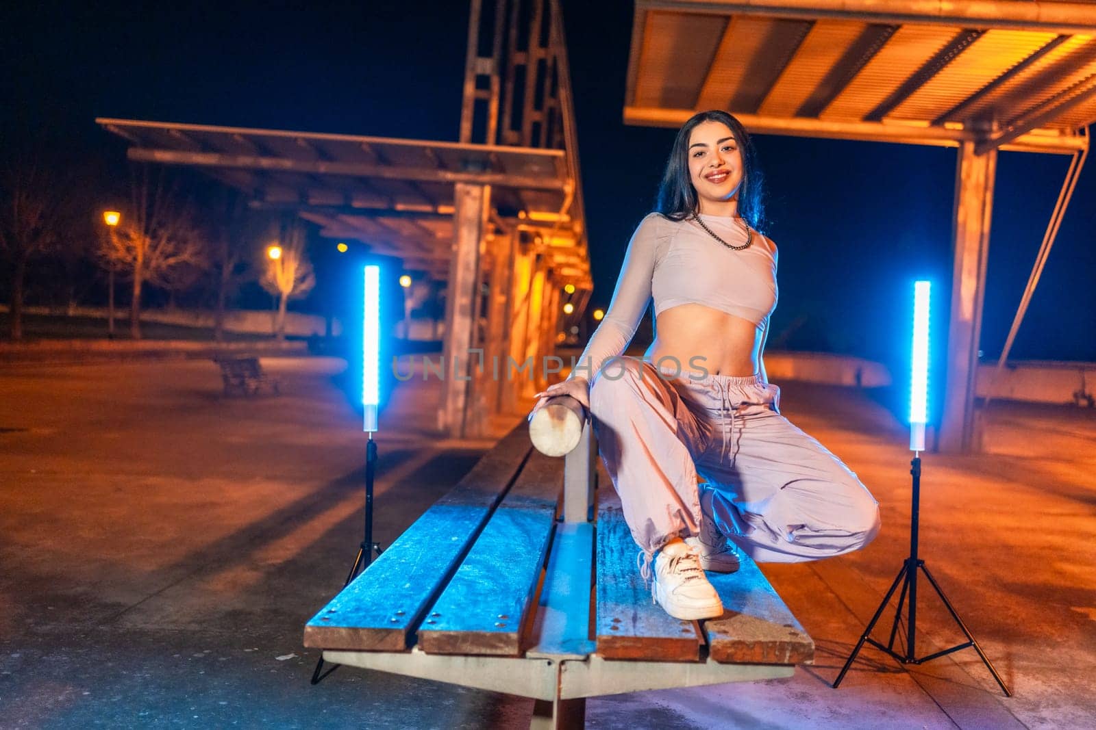 Trap artist posing crouching in an urban park at night by Huizi