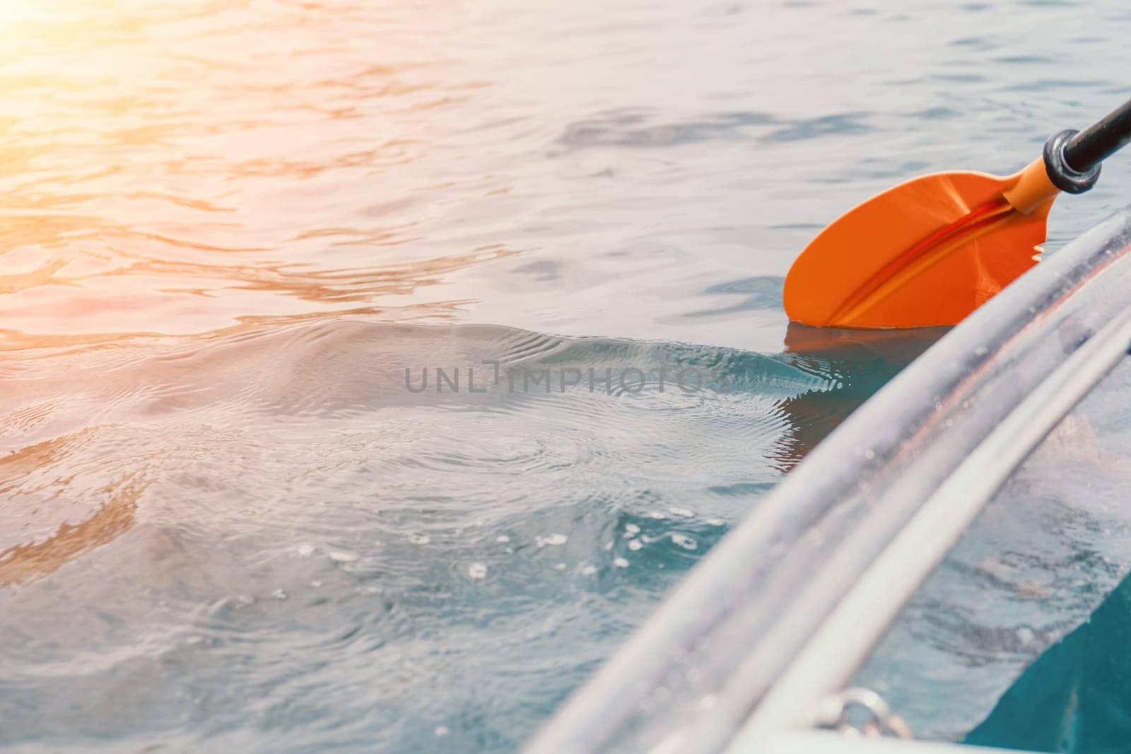 Woman in kayak back view. Happy young woman with long hair floating in transparent kayak on the crystal clear sea. Summer holiday vacation and cheerful female people having fun on the boat.