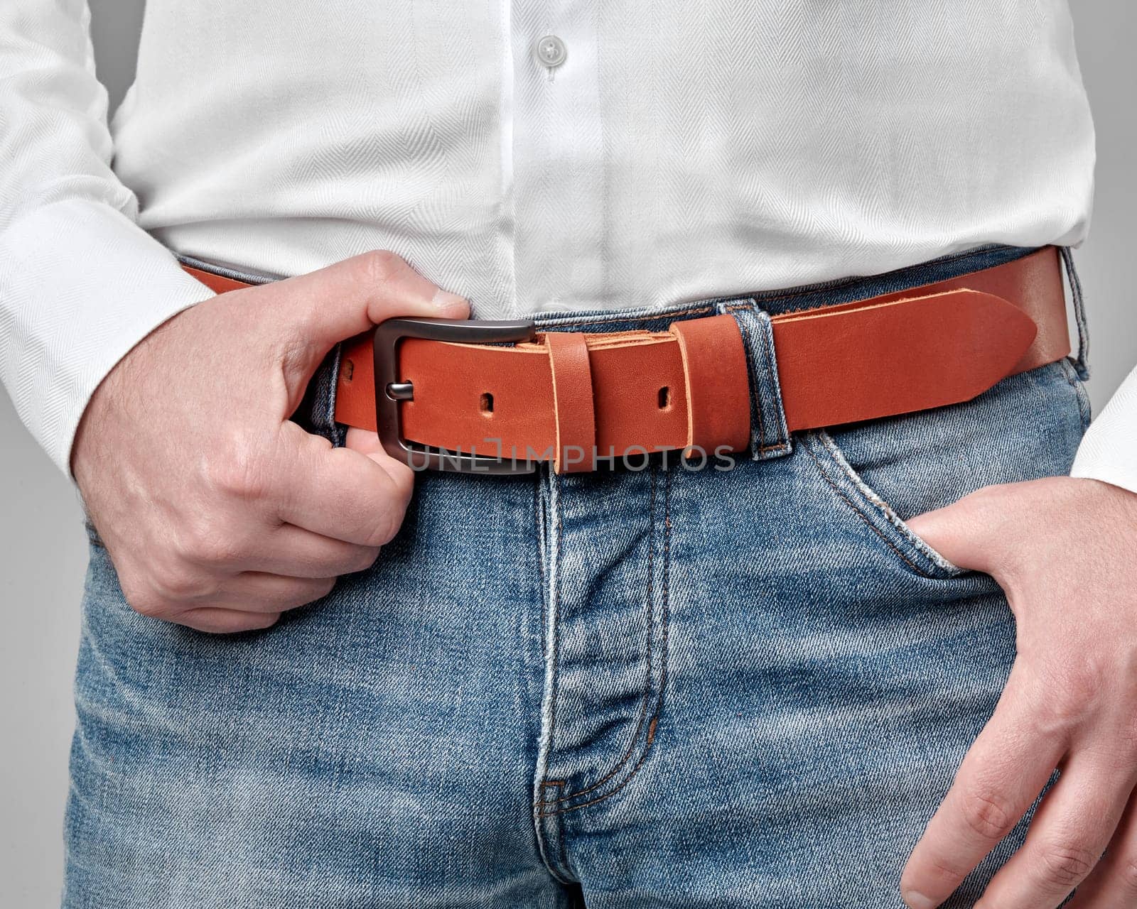 Cropped view of man wearing custom embossed leather belt by nazarovsergey