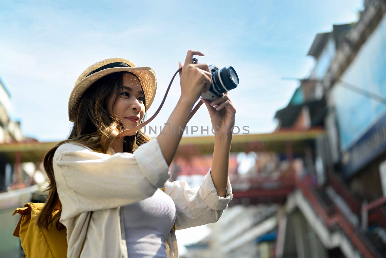 Young woman enjoy traveling and taking photo in local city street in Chiang Mai, Thailand.