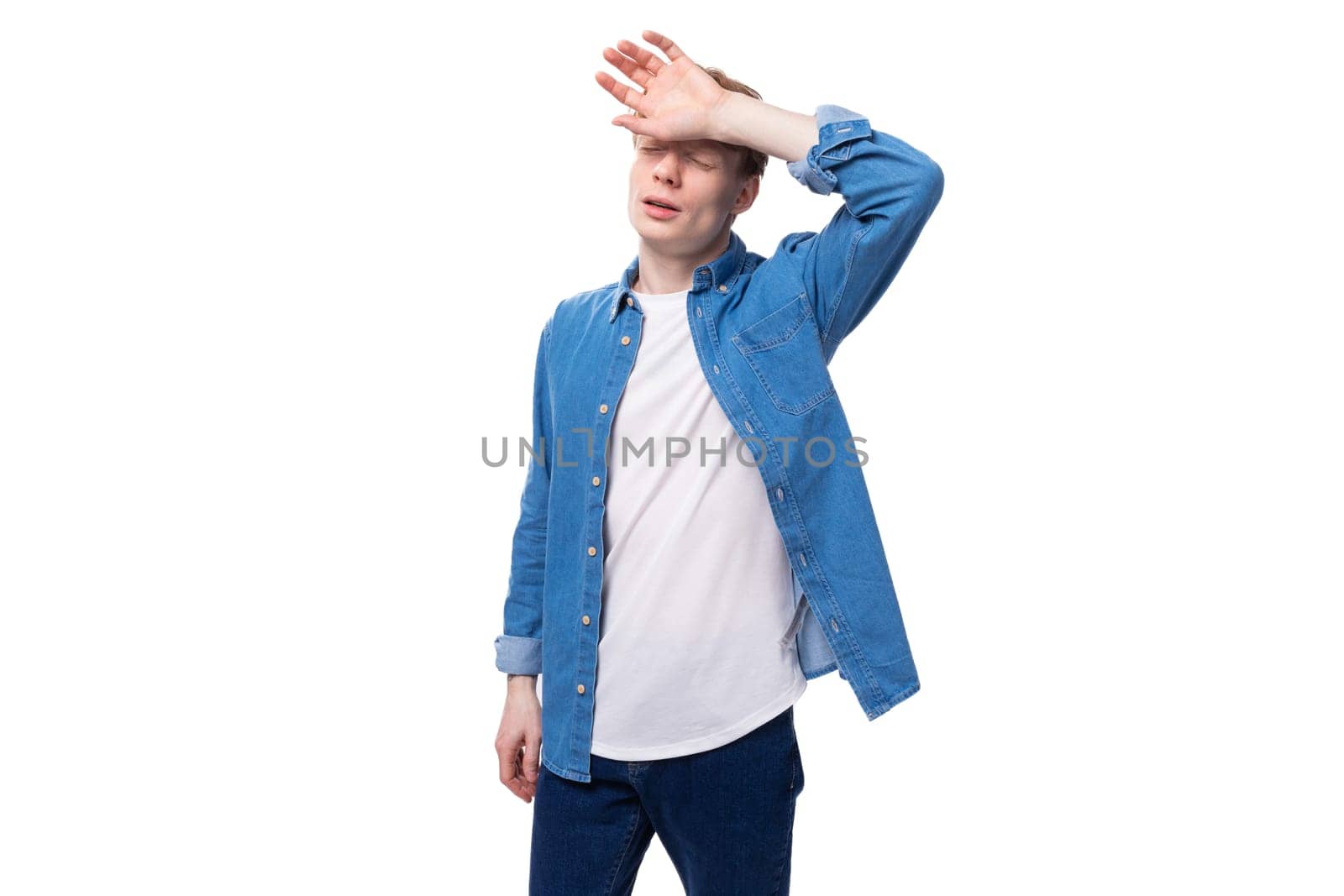 young european man with red hair wears a blue denim shirt thinks about an idea.