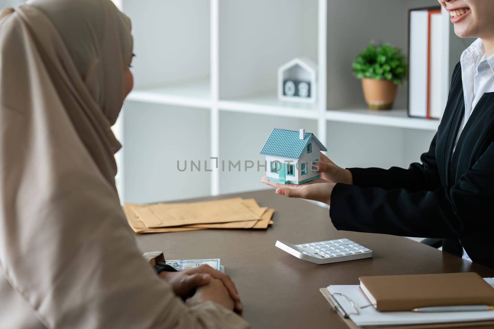 real estate agent talk about terms of home purchase agreement and ask Muslim customer to sign document to make the contract legally by itchaznong