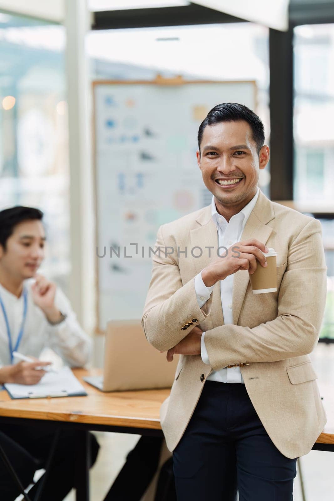 Portrait of a confident businessman standing in the boardroom during a meeting by itchaznong