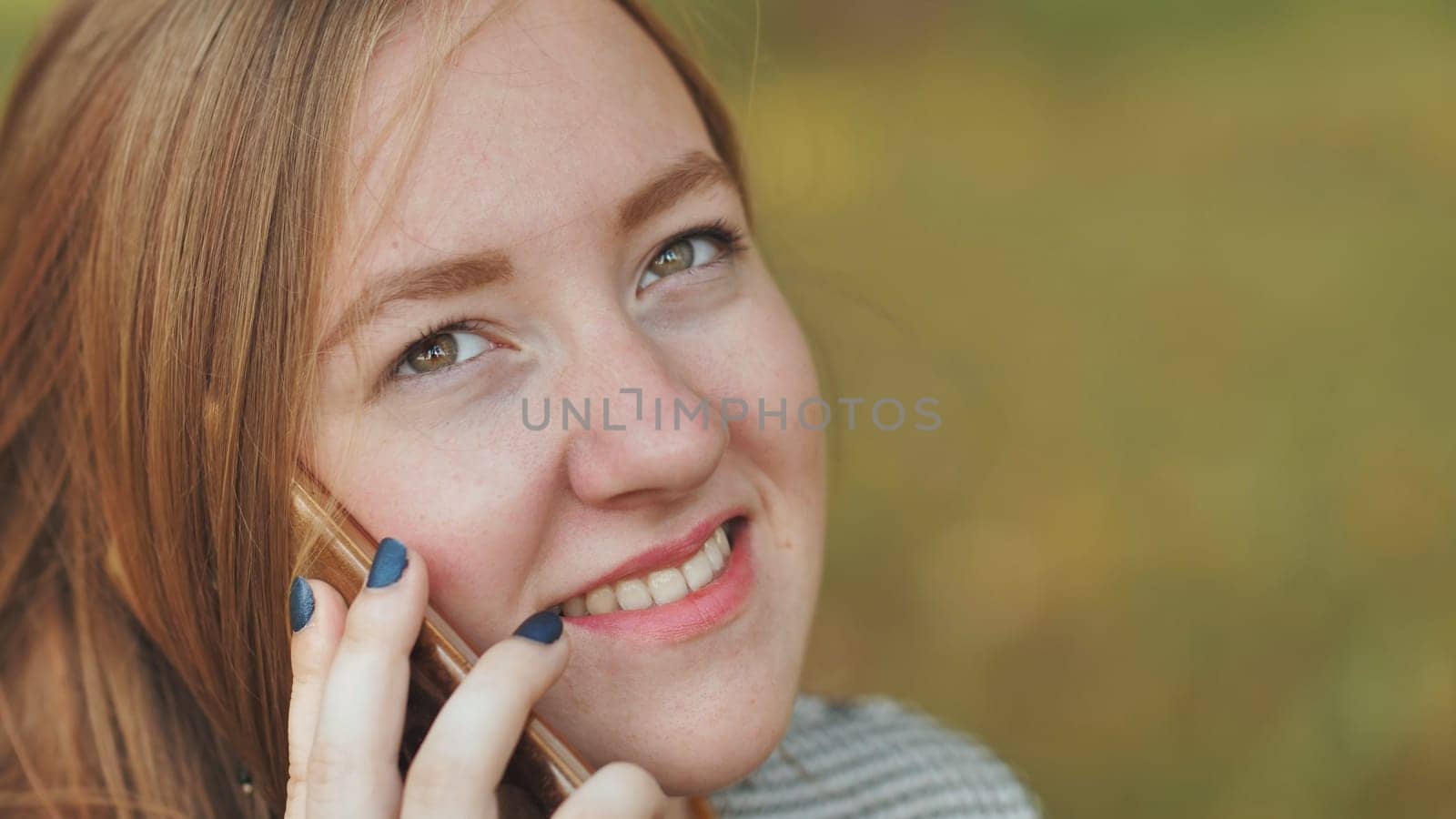 A young girl talking on the phone. Close-up of her face