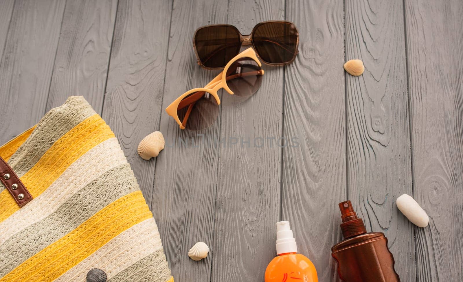 beachwear bag sun protection sunglasses sunscreen spray lotion cream care tan ultra-violet rays. Summer background template mockup free space pattern composition text. Top view above wooden background