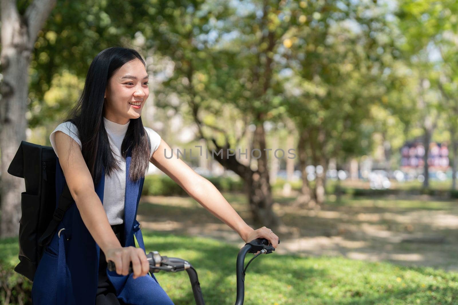 Eco friendly, Happy lifestyle asian beautiful young businesswoman riding bicycle go to office work at city street with bicycle in morning.