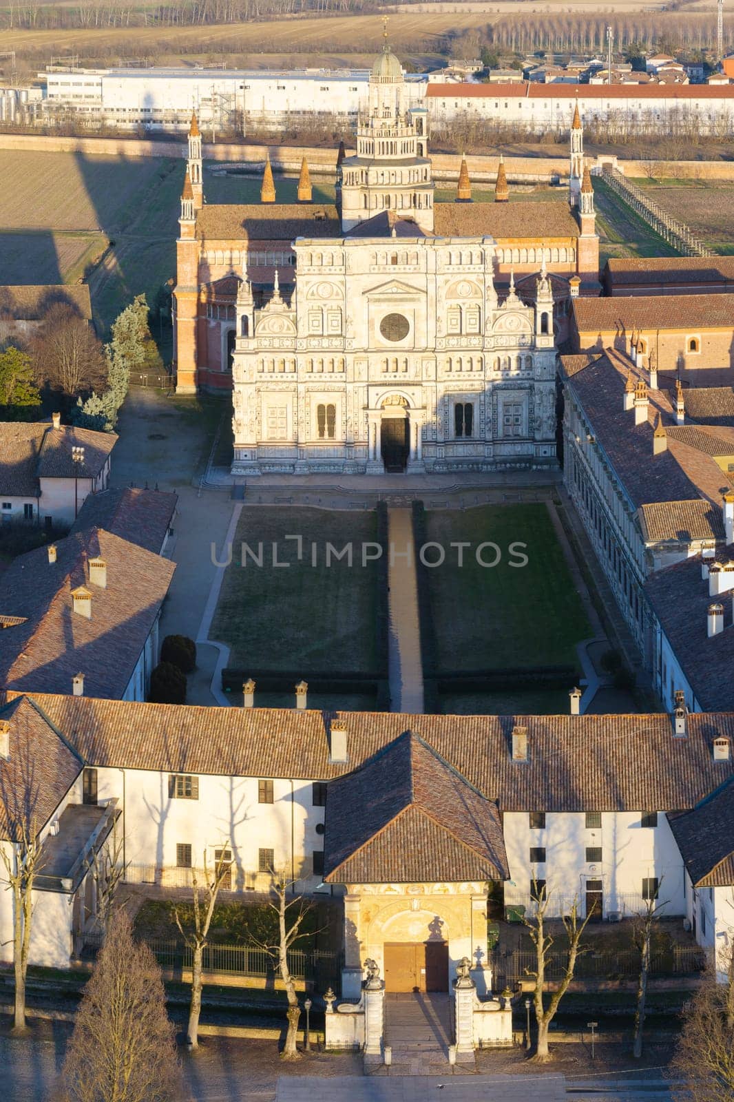 Drone view over Certosa di Pavia monastery with lawn fields in Italy, Pavia