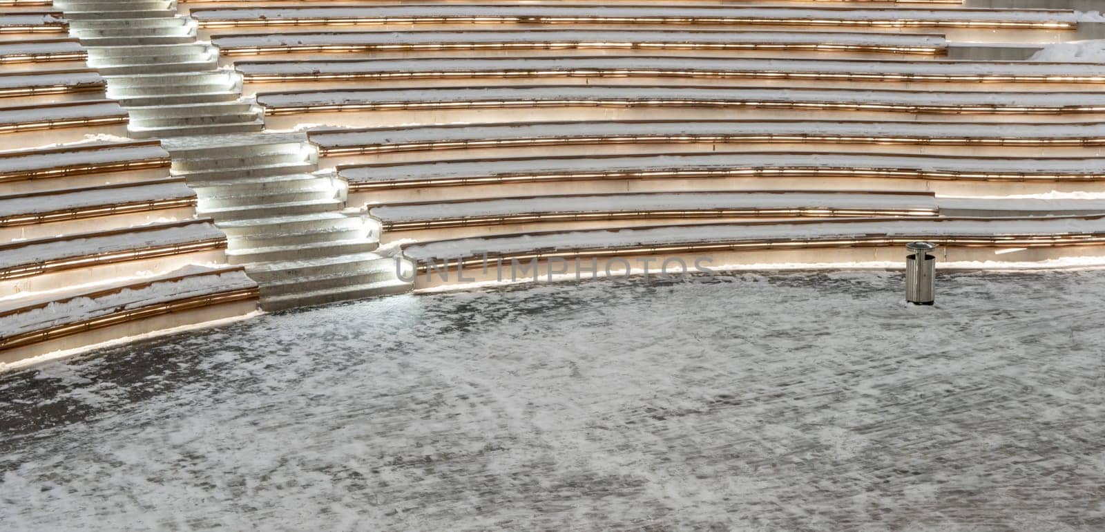 Open-air benches covered with snow in Moscow Polytech amphitheatre. low light. no people. by lempro