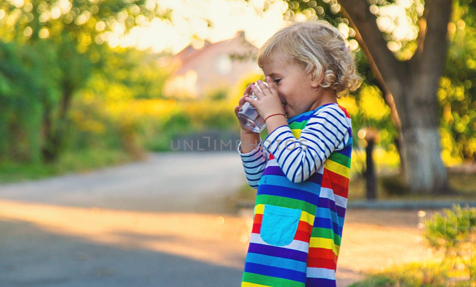 a child drinks water from a glass. Selective focus. by yanadjana