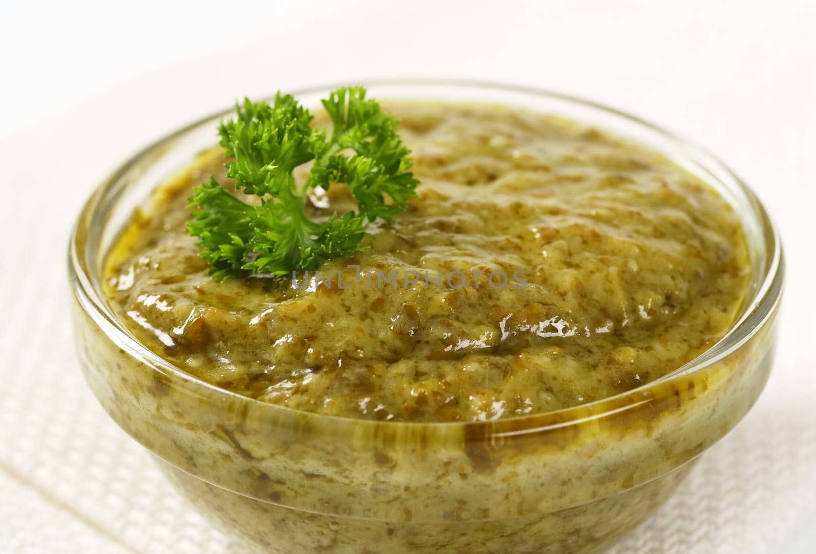 Closeup of basil pesto in glass bowl