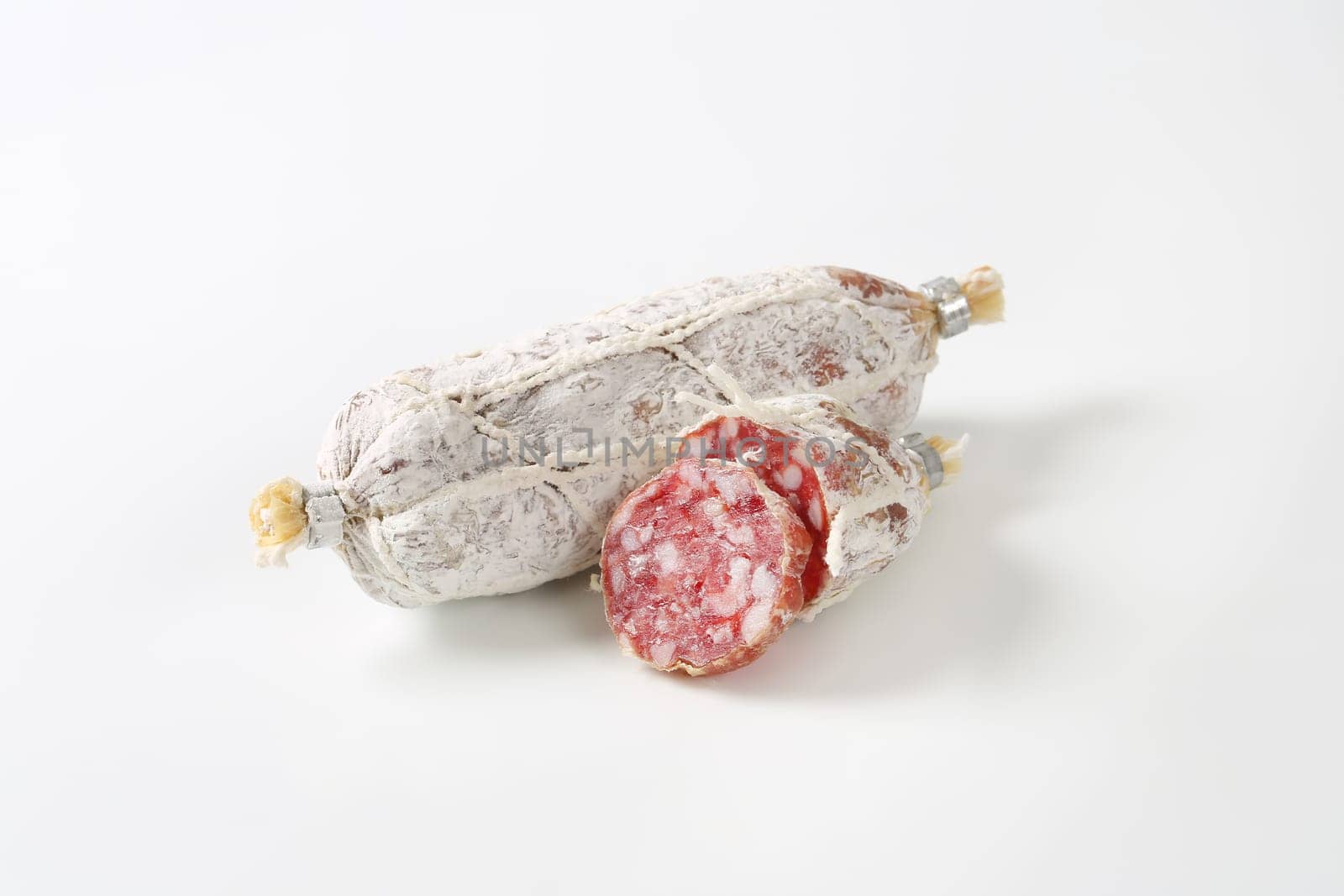 Dry cured French sausage on white background