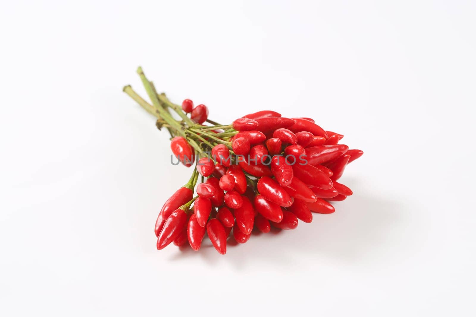 Bunch of small red chili peppers on white background