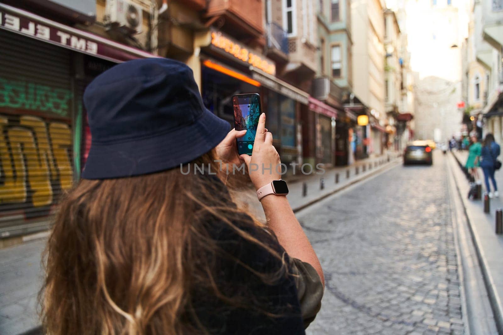 ISTANBUL, TURKEY - 08.05.2021: Young woman photographs the sights of Istanbul on her phone. High quality photo