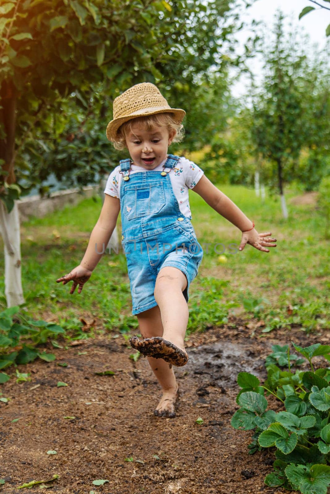 a child in the dirt in the garden holds the soil in his hands. Selective focus. Kid.