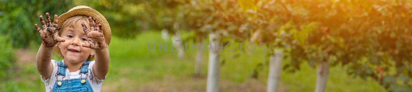 a child in the dirt in the garden holds the soil in his hands. Selective focus. Kid.