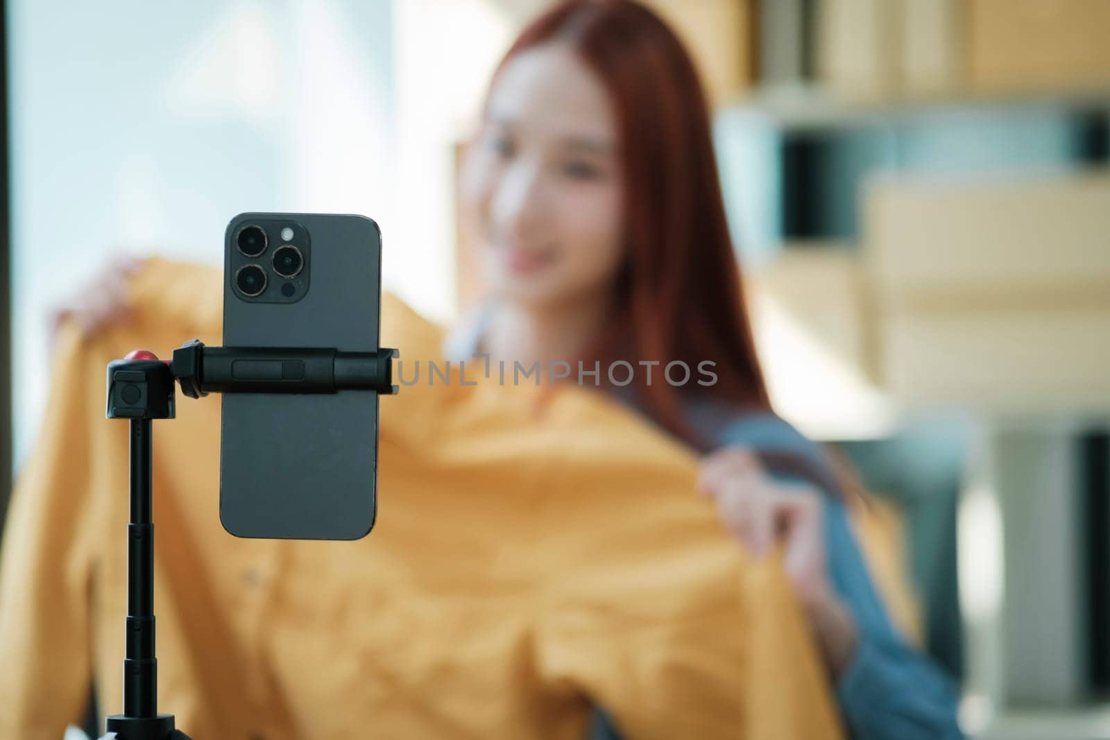 Woman with a social media influence is greeting the audience for recording vlog video live streaming, Lift the postage box during the live show to confirm the customer's order, Online fashion clothing