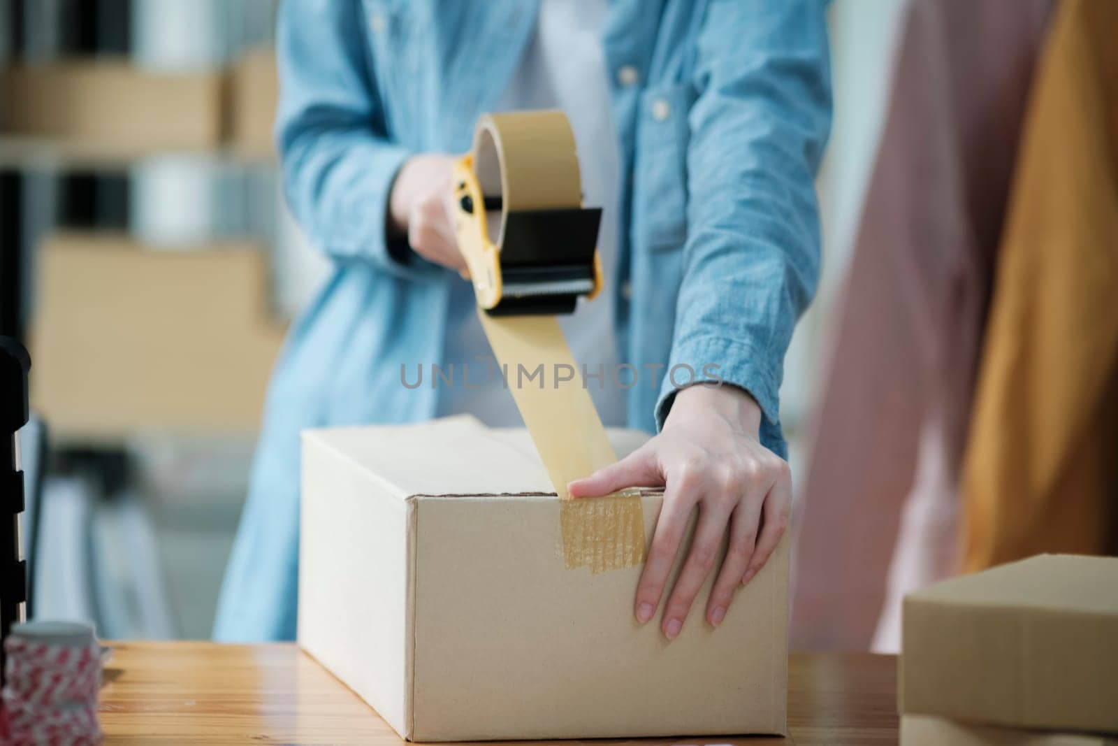 Woman packing box, package and cargo with tape for delivery, sale and shipping in workshop, startup store and creative studio.