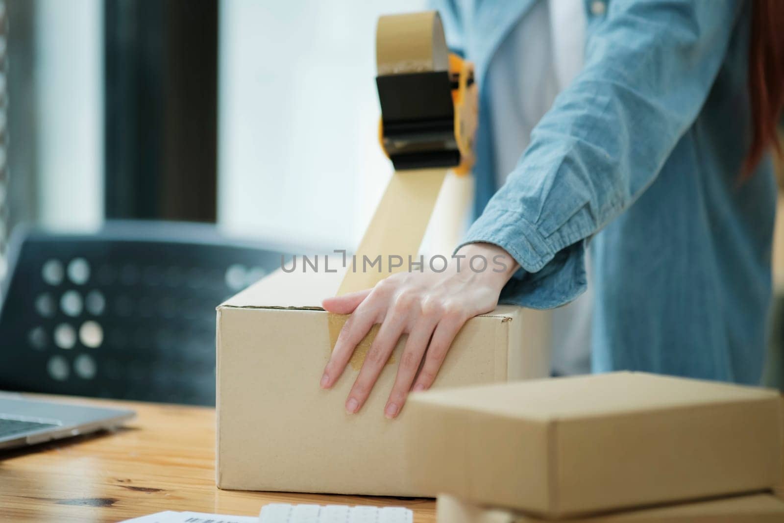Woman packing box, package and cargo with tape for delivery, sale and shipping in workshop, startup store and creative studio.