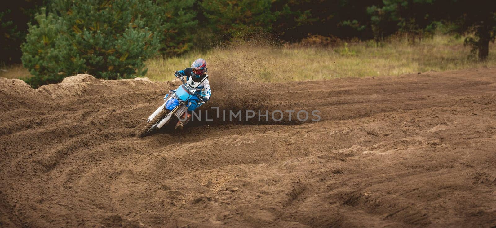 Moto cross - MX girl biker at race in Russia - a sharp turn and the spray of dirt, telephoto