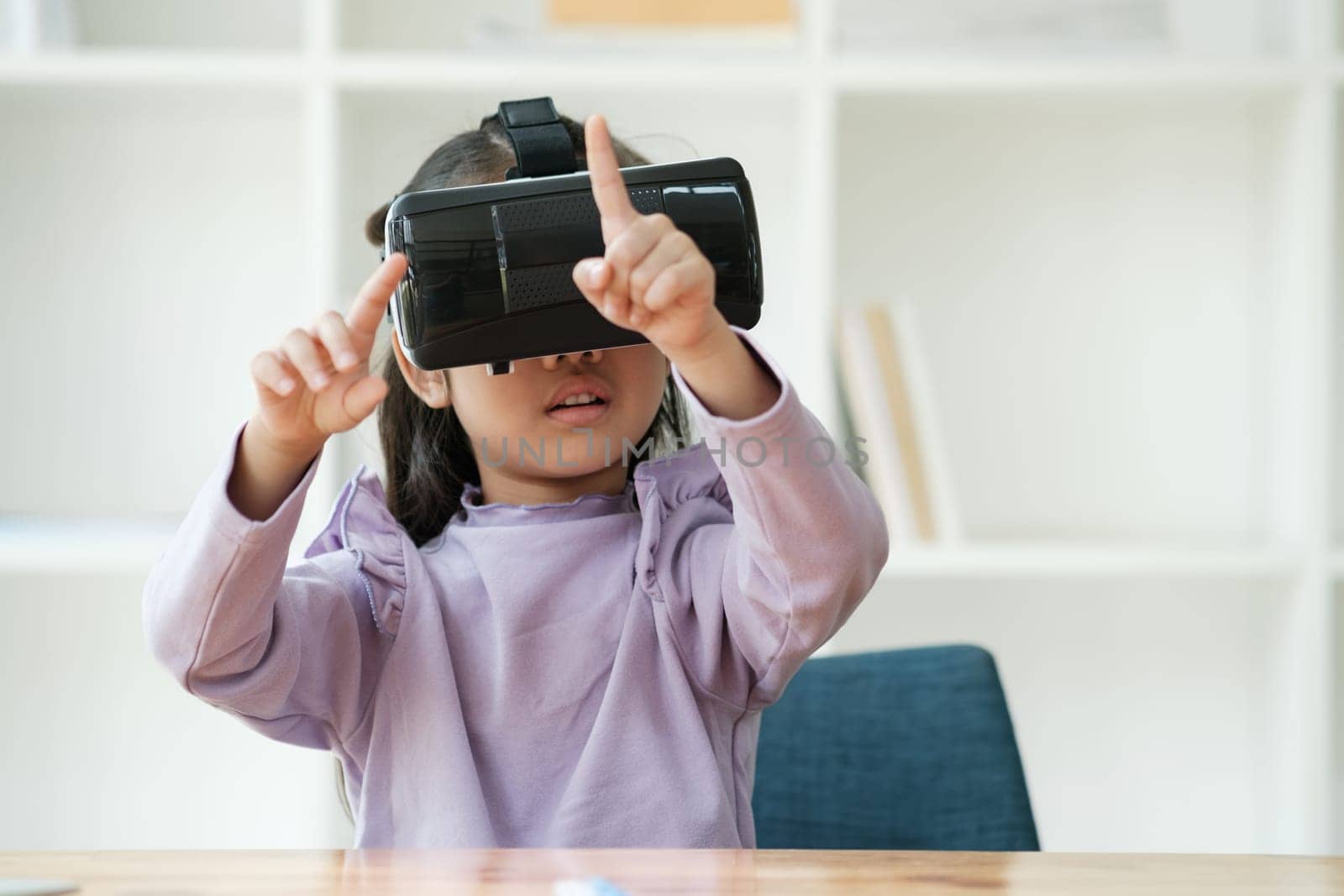 An elementary aged girl uses a virtual reality headset to enhance learning experience with excitement. Marketing for VR products, educational technology content.