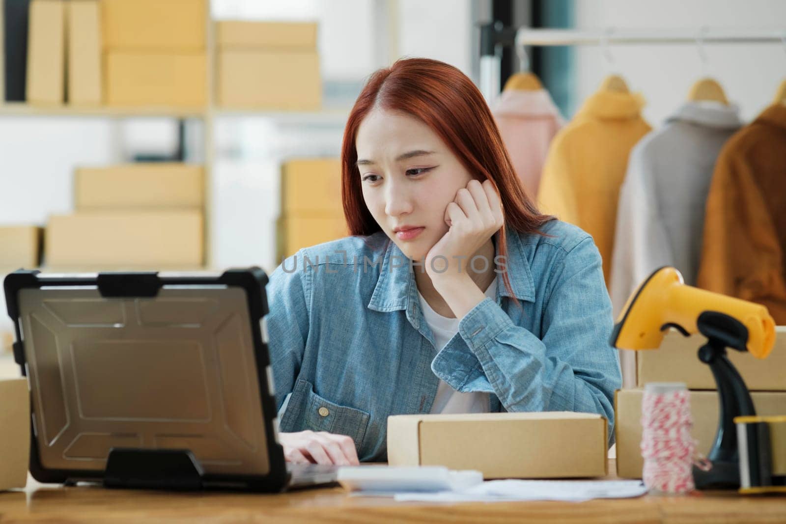 Woman seller SME retail owner feeling upset and disappointed about her recent sell record. by ijeab