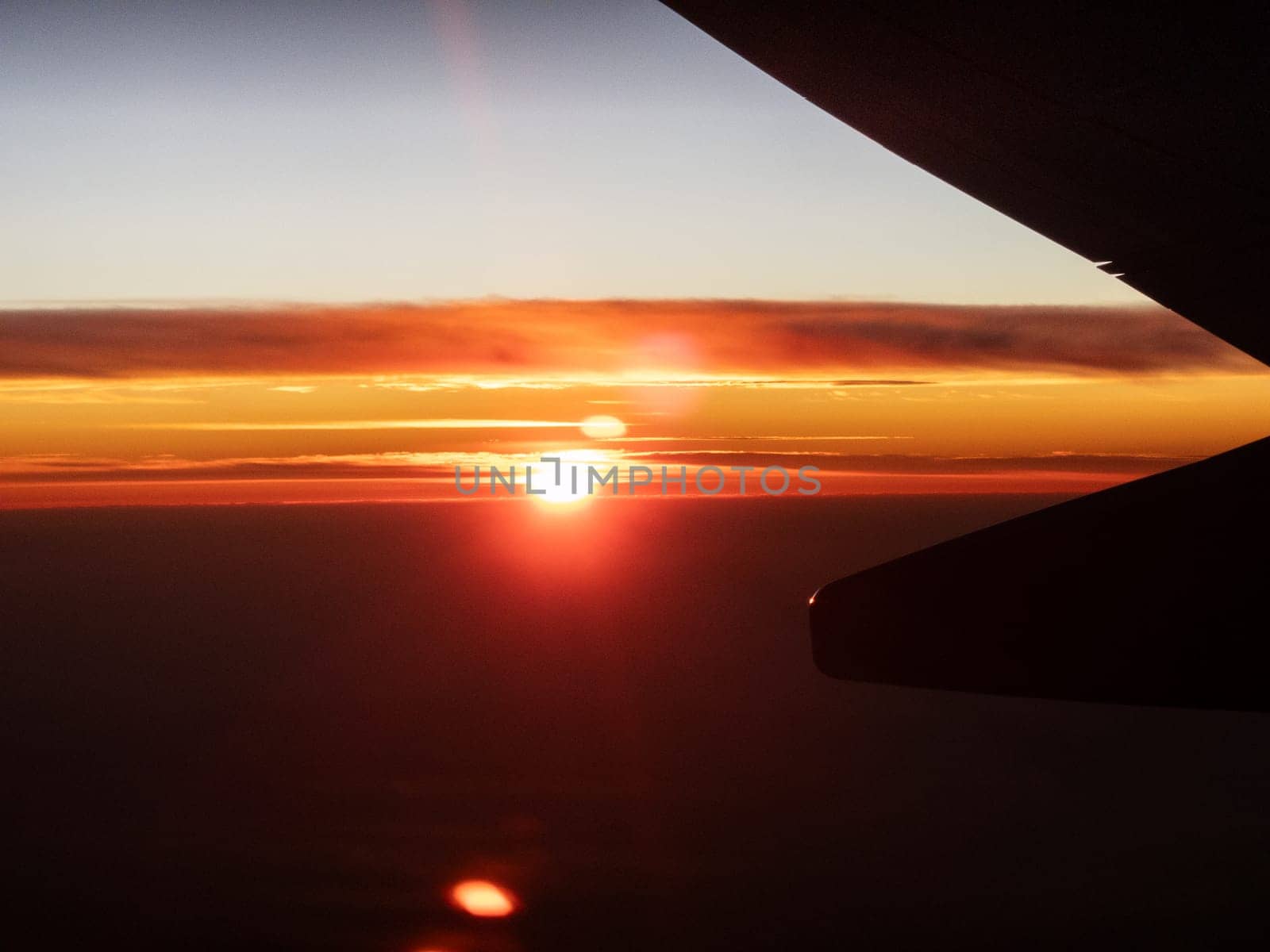 Stunning sunset seen from above clouds on a plane.