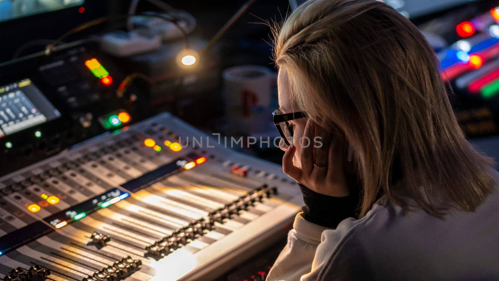 Russia October 2020. the girl sound engineer works works on the broadcast at the sound console. low light