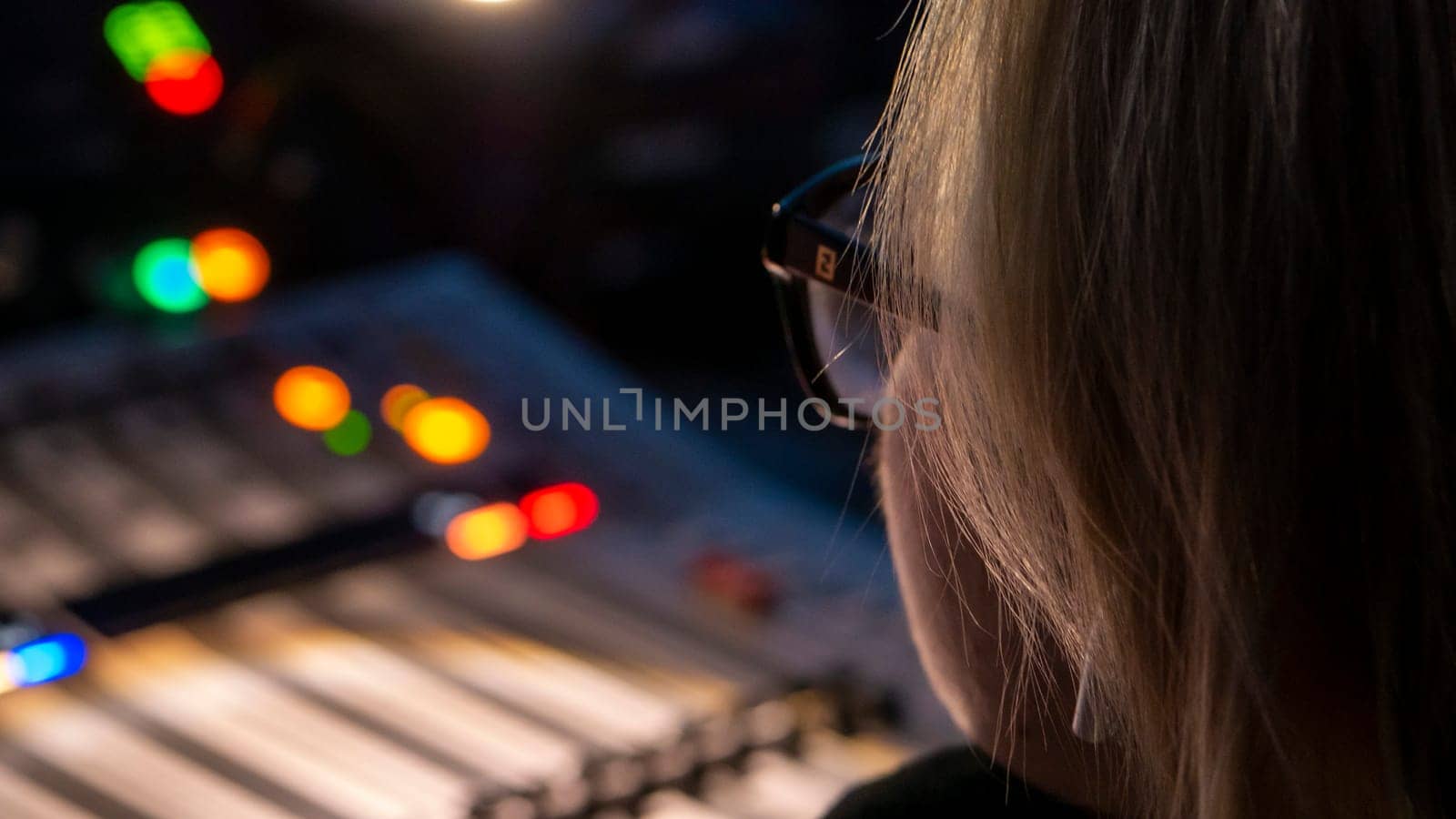 Russia October 2020. the girl sound engineer works works on the broadcast at the sound console. low light