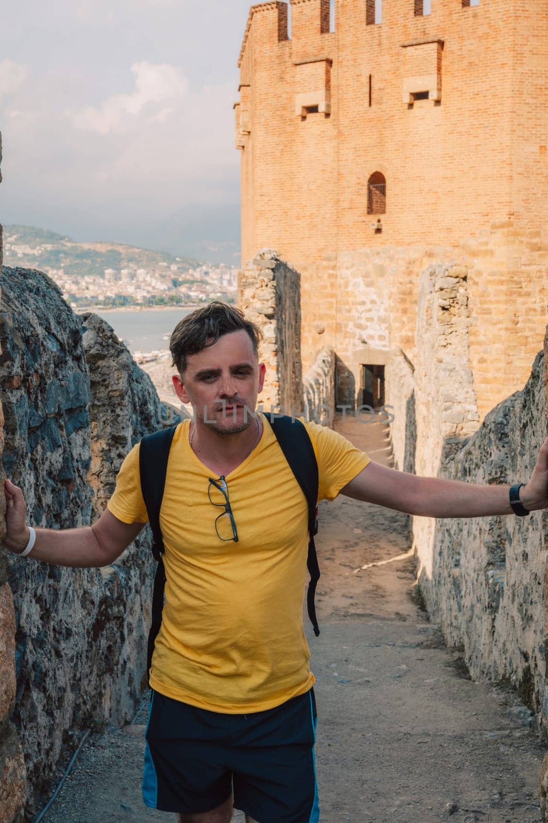 Man at fortress ruins of the historical Red Tower - Kizil Kule, in Alanya Castle, the famous touristic place.