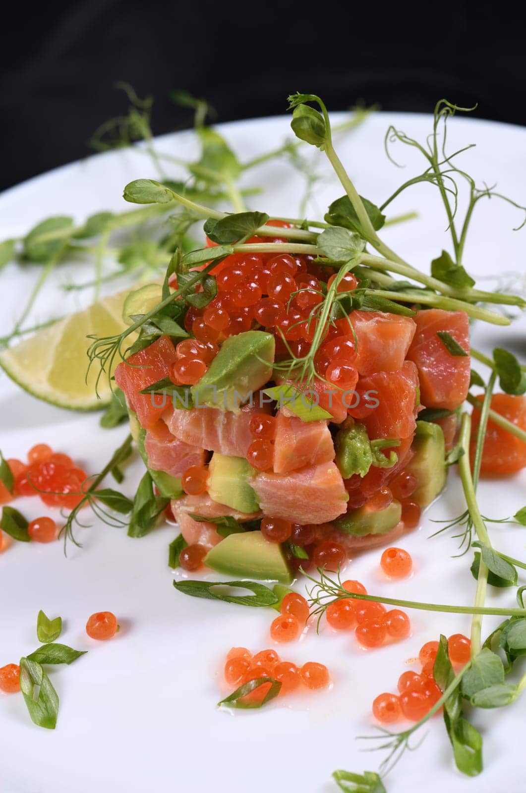 Avocado tartare with salmon, red caviar and pea sprouts.