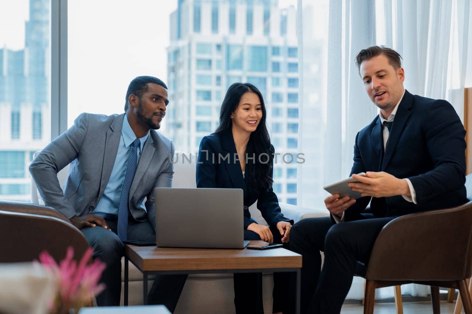 Smart caucasian businessman present marketing idea by using tablet. Group of business team listening while deciding to invest in start up project at modern lounge. Ornamented.