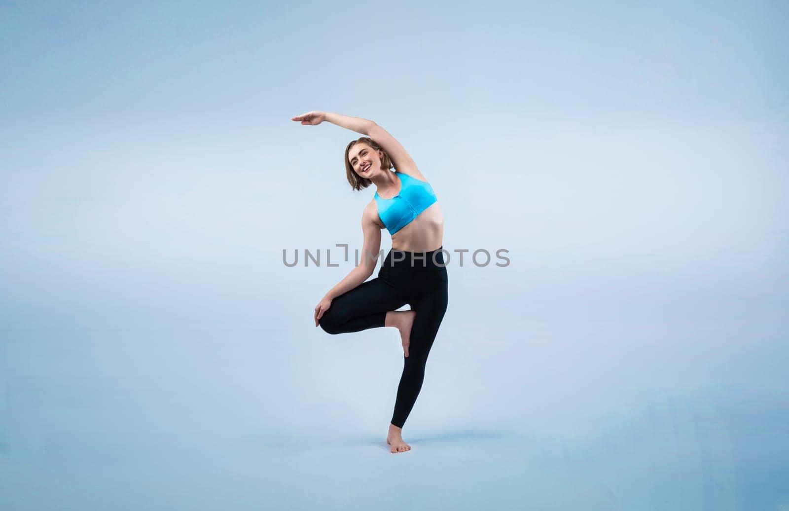 Full body length gaiety shot athletic and sporty woman doing yoga by biancoblue