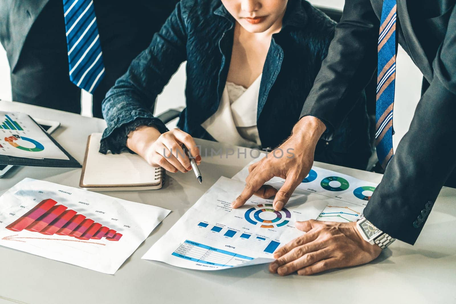 Businessman and businesswoman in meeting working with many financial statement document on desk. Concept of busy business profit analysis and brainstorm. Close up shot at people hands and papers. uds