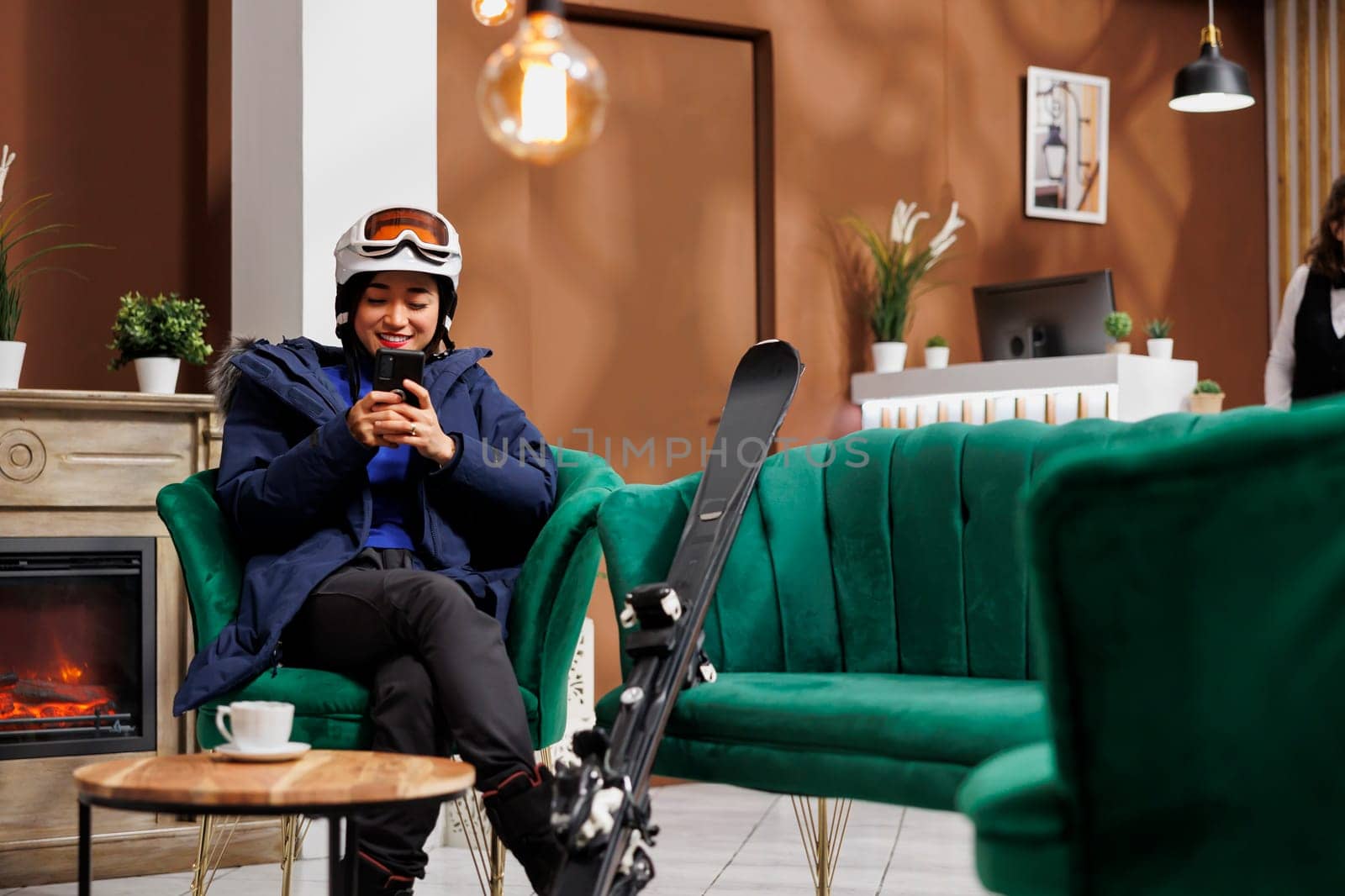 Traveler browisng phone in ski resort by DCStudio