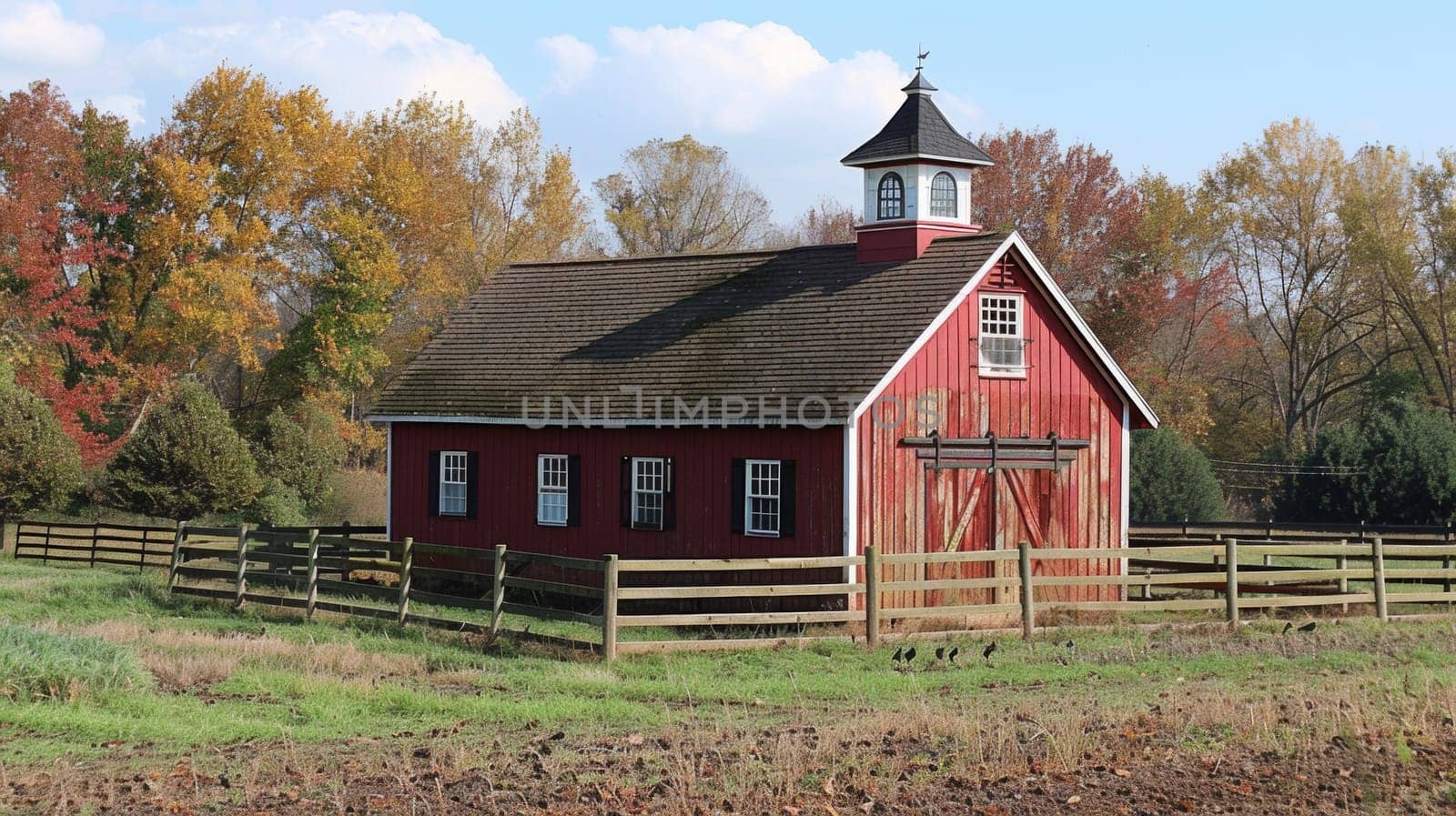 A small red barn with a steeple in the middle of an open field, AI by starush