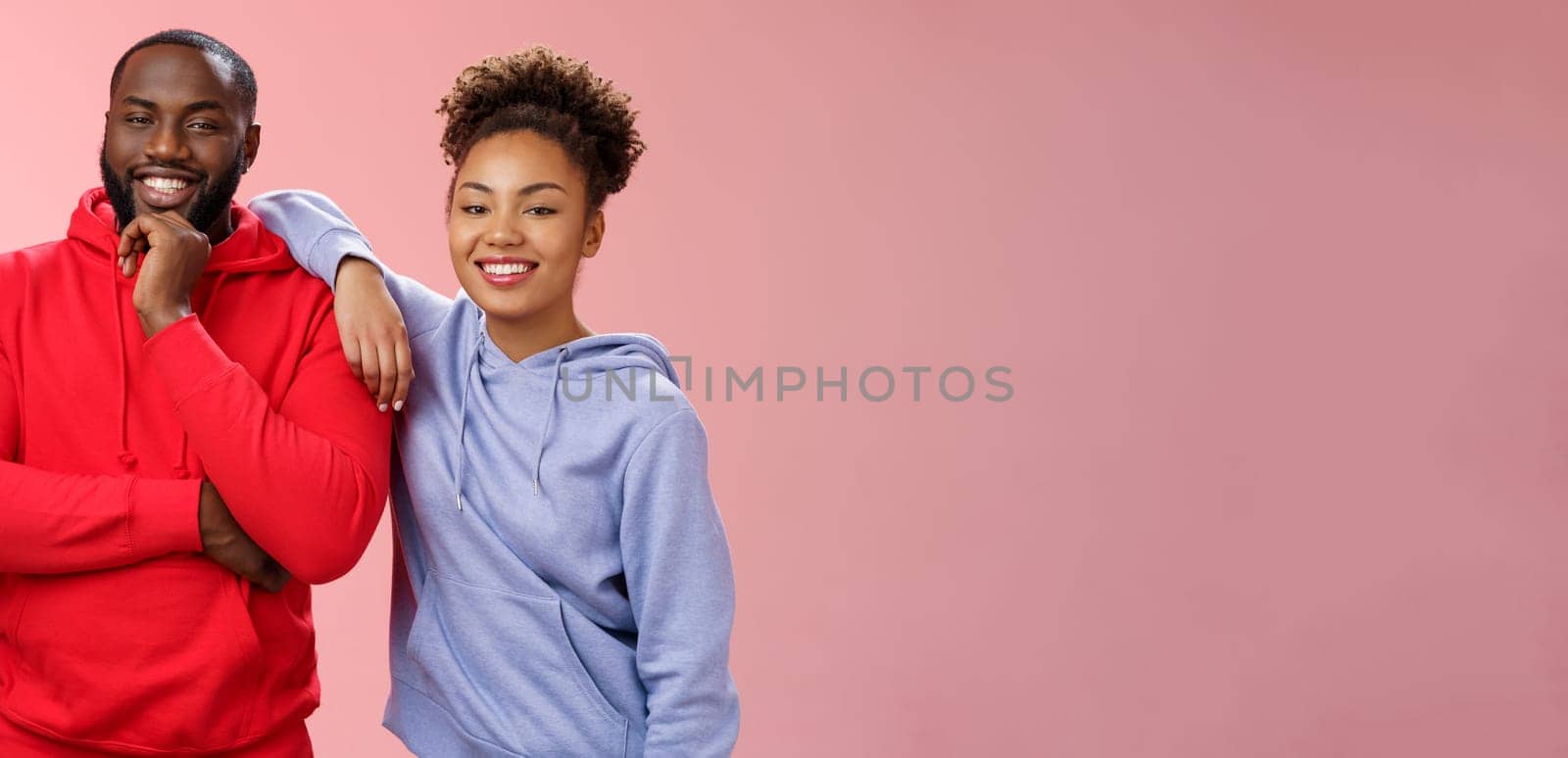 Romantic couple best friends standing pink background girl leaning boyfriend shoulder smiling broadly feel love respect each other working team standing pleased delighted friendly look camera by Benzoix